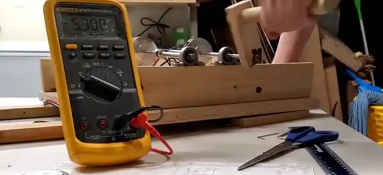 Christopher spins the crank of the device and the multimeter shows it's generating over 5V